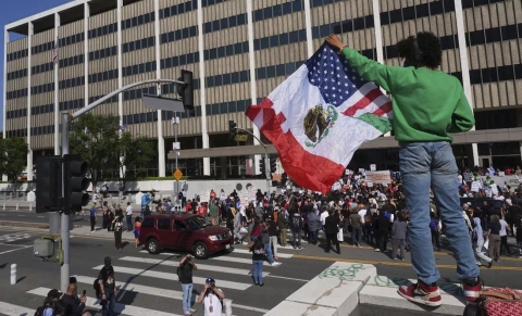 Una persona sostiene una bandera mexicana-estadounidense el viernes 6 de junio de 2025, después de autoridades federales de inmigración llevaran a cabo un operativo migratorio