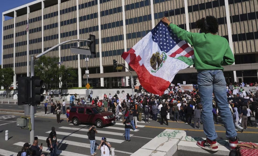 Una persona sostiene una bandera mexicana-estadounidense el viernes 6 de junio de 2025, después de autoridades federales de inmigración llevaran a cabo un operativo migratorio
