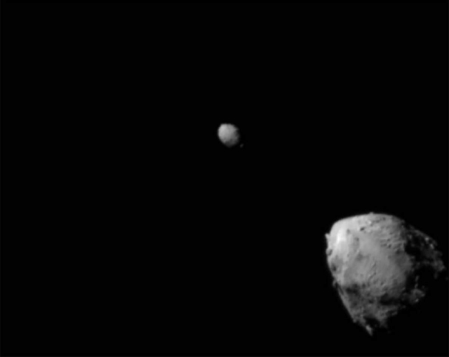 El asteroide Didymos (arriba a la izquierda) y su luna, Dimorphos, unos 2,5 minutos antes del impacto de la nave espacial DART de la NASA. La imagen fue tomada por el generador de imágenes DRACO a bordo de la nave desde una distancia de 920 kilómetros. Esta imagen fue la última en obtener una vista completa de ambos asteroides. 