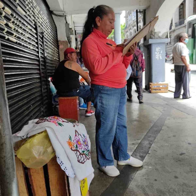 Checadora de rutas también vende servilletas bordadas 