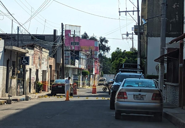 Un perito observa los cartuchos percutidos que quedaron en una de las calles donde actuó el comando armado.