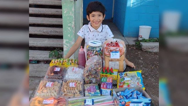 Niño vende dulces para pagar sus útiles escolares