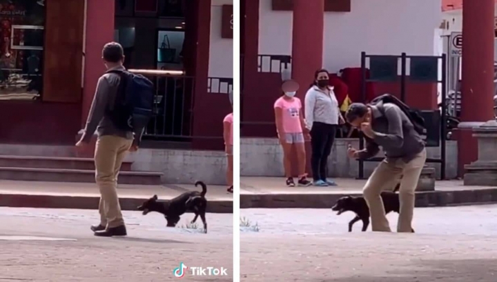 Un hombre y un perro se divierten bailando en plena vía pública.