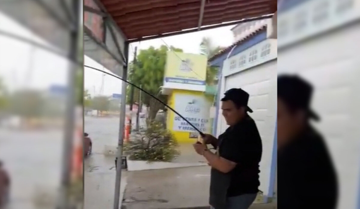 Hombre saca su caña y se pone a pescar durante una inundación