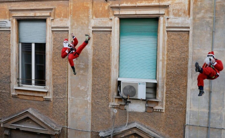 Santa Claus hace rappel para llevar regalos a niños.