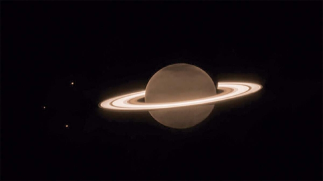 Imagen de Saturno y algunas de sus lunas, capturada por el instrumento NIRCam del Telescopio Espacial James Webb el 25 de Junio de 2023. En esta imagen monocromática, el filtro NIRCam F323N (3,23 micras) se mapeó en color con un tono naranja. 
