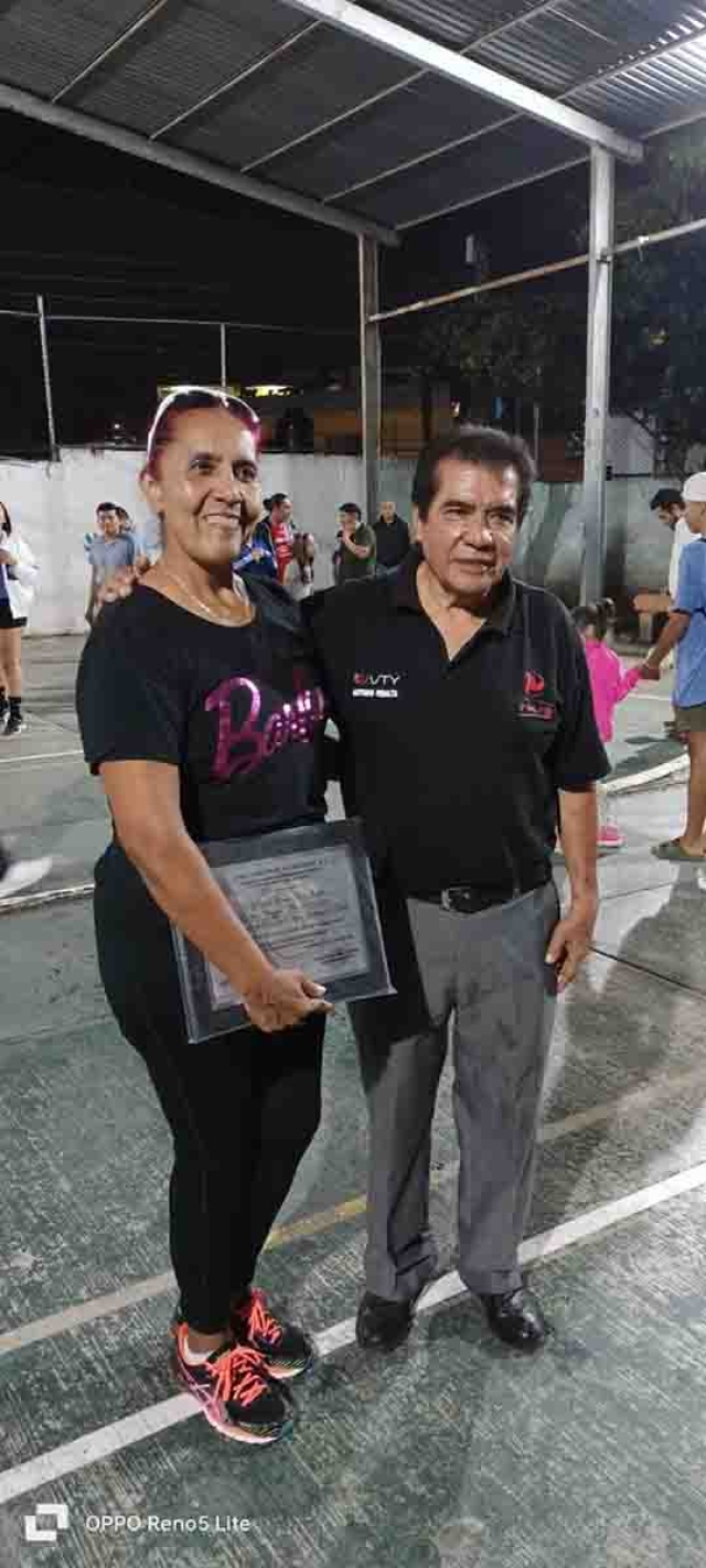 Antonio Peralta, coordinador de la Liga Industrial de Voleibol, hizo entrega de un reconocimiento a Lourdes Lara Jaimes.