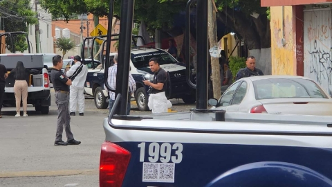   La maleta fue abandonada sobre la acera, junto a un auto blanco.